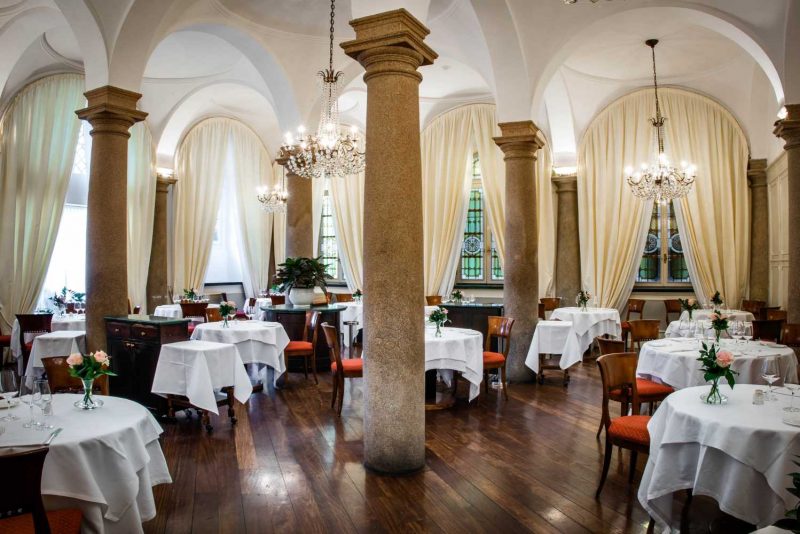 Salão com mesas e cadeiras do Restaurante Boeucc em Milão.