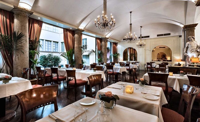 Interior do Restaurante Boeucc em Milão. A sala abriga uma decoração antiga e elegante