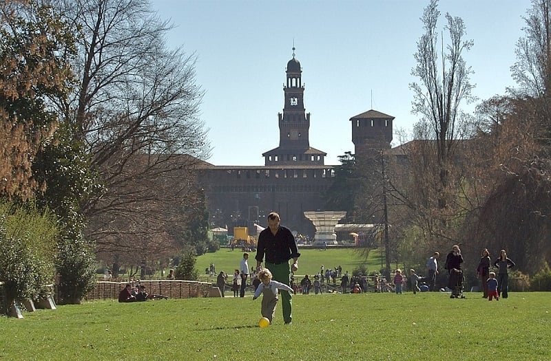 Pai e filho jogam bola no Parque Sempione em Milão.