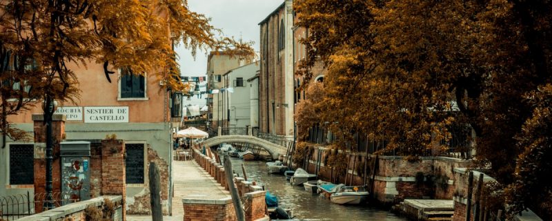 Vista de uma parte da cidade de Veneza, com um canal e barcos, durante o outono.