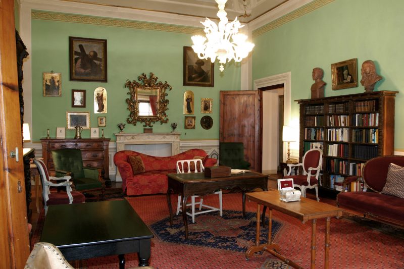 Interior da Casa Guidi em Florença. Nota-se uma sala de paredes verdes com móveis e pinturas que pertenceram ao casal.