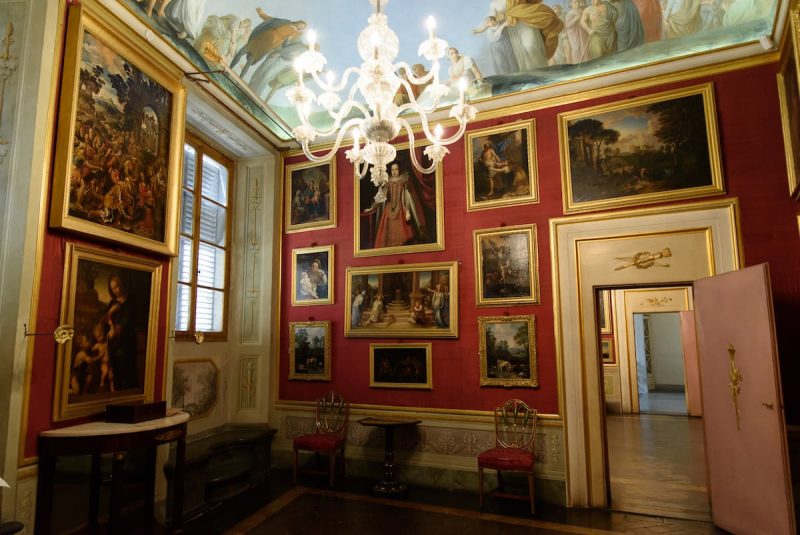 Interior do museu Casa Martelli. Nota-se uma exposição de quadros numa sala vermelha.