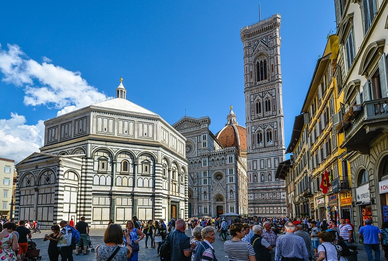 Vista da Piazza del Duomo com muitas pessoas andando por lá.